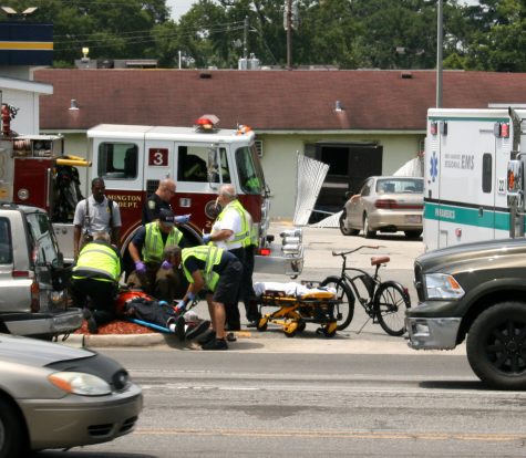 Emergency responders tend to a bicyclist who was struck by a car at the intersection of Market Street and Kerr Avenue on July 30. New Hanover ranks second in the state in AAA Carolinas' latest rankings of the most dangerous counties for vehicle collisions. File photo by Christina Haley.