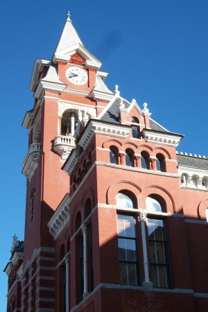 The 19th-century courthouse features a red-and-gray, brick-and-stone appearance—a signature of architect Alfred Eichberg.