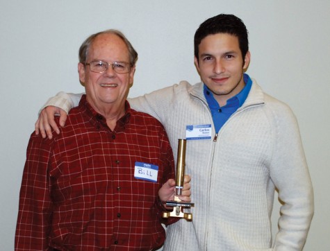 Bill Culpepper displays the Golden Microscope Award he received alongside Carlos Ramos, who was named Cape Fear Museum's Volunteer of the Year. Photo courtesy Cape Fear Museum.