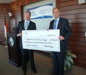 John Elliott, Director of East Region Government and Community Relations for Duke Energy, hands over a check to CFCC President Dr. Ted Spring today to help fund a new welding program in Burgaw. Photo by Hilary Snow.
