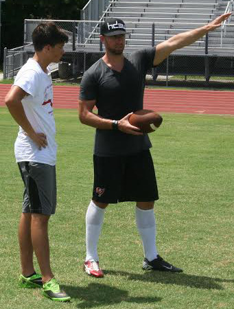 Connor Barth, right, works with Laney junior Josiah Eason during the Barth kicking clinic at Hoggard. Photo by Lee Wagner