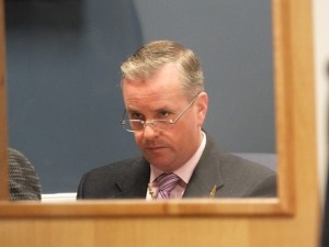 Elections Director Marvin McFadyen is seen through a door window listening to board members during the closed session. Photo by Jonathan Spiers.