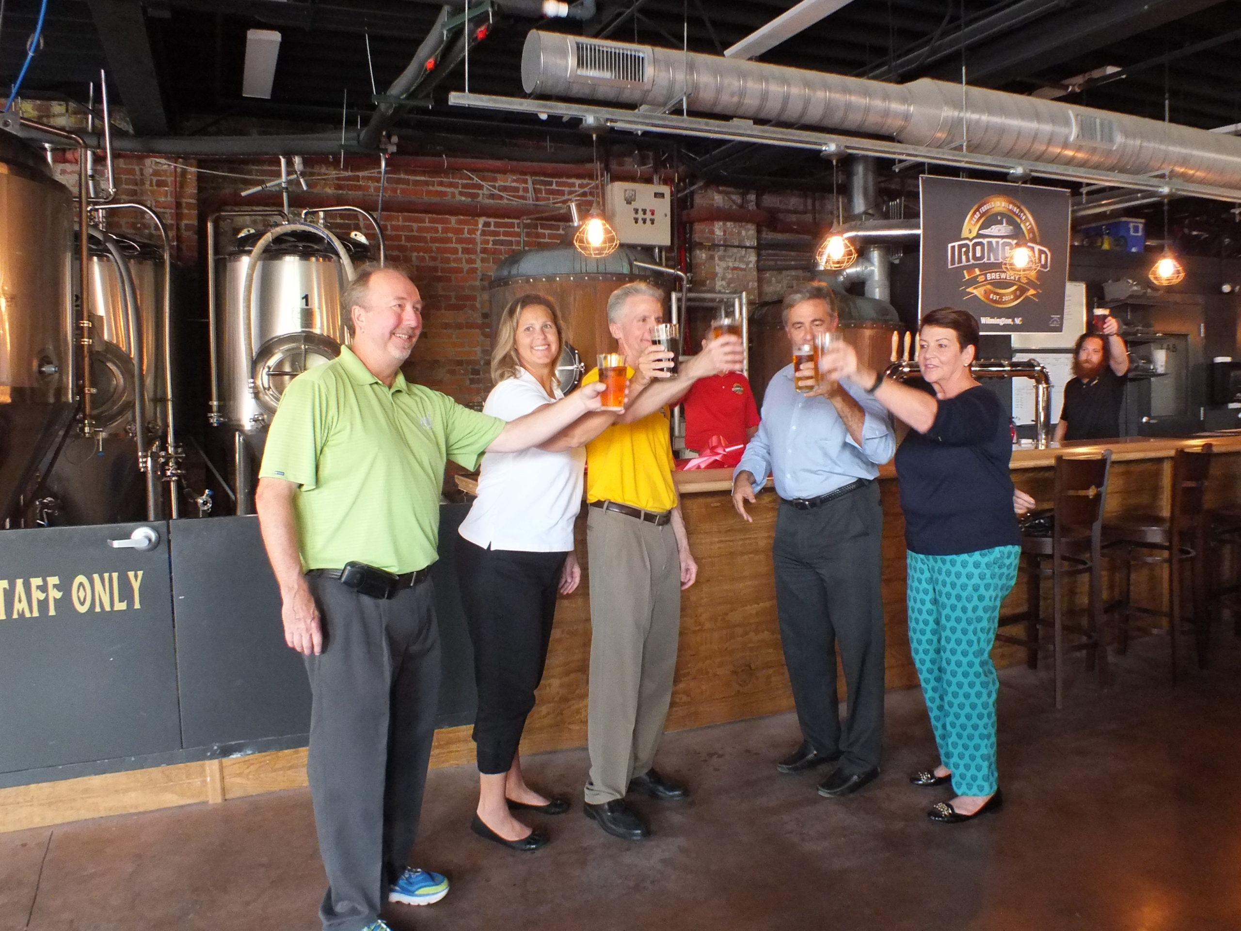 From left, Ed Wolverton of Wilmington Downtown, Inc., Ironclad Brewing owners Michelle and Ted Coughlin, Wilmington mayor Bill Saffo and mayor pro tem Margaret Haynes celebrate the official opening of Ironclad Friday. Photo by Hilary Snow.