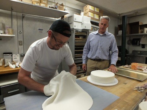 Apple Annie's owner Rob Cooley, right, watches as baker Hans Westermark begins the process of building a custom baby shower cake. Cooley and his staff will celebrate the local fixture's 30th birthday later this month. Photo by Hilary Snow.
