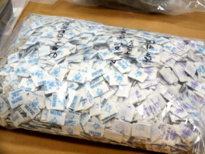 Stamps like the blue and purple labels found on each small bag of heroin in this photo, are used to specify a brand of the drug. Photo by Christina Haley.