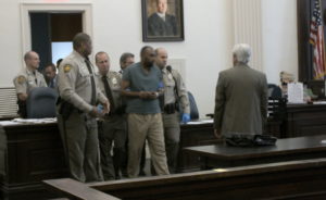 Multiple deputies escorted Darrell Taylor into court Monday morning. He has been charged with the deaths of a woman and her daughter. Photo by Christina Haley.