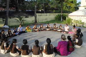 Wilmington Yoga Center members and Indian girls come together in a circle. Courtesy of Wilmington Yoga Center.