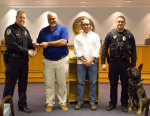 Tim Morrison and Wayne Rouse of Crawl for Paws present a check to the Carolina Beach Police Department for their K9 Unit. Photo by Hannah Leyva.