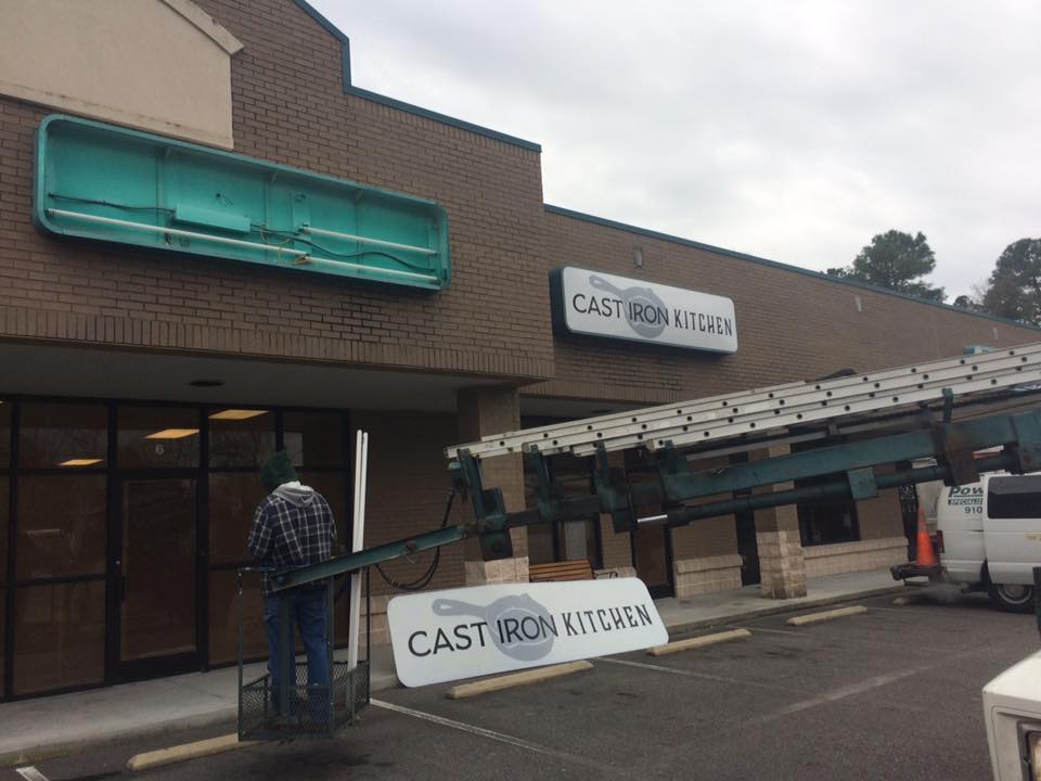 Crews hoist signs for the restaurant, which will occupy the former Hungry Heroes location and an adjacent space.