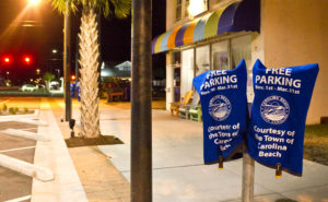 Parking meters along the 100 block of Cape Fear Boulevard covered in the off-season. Photo by Hannah Leyva.