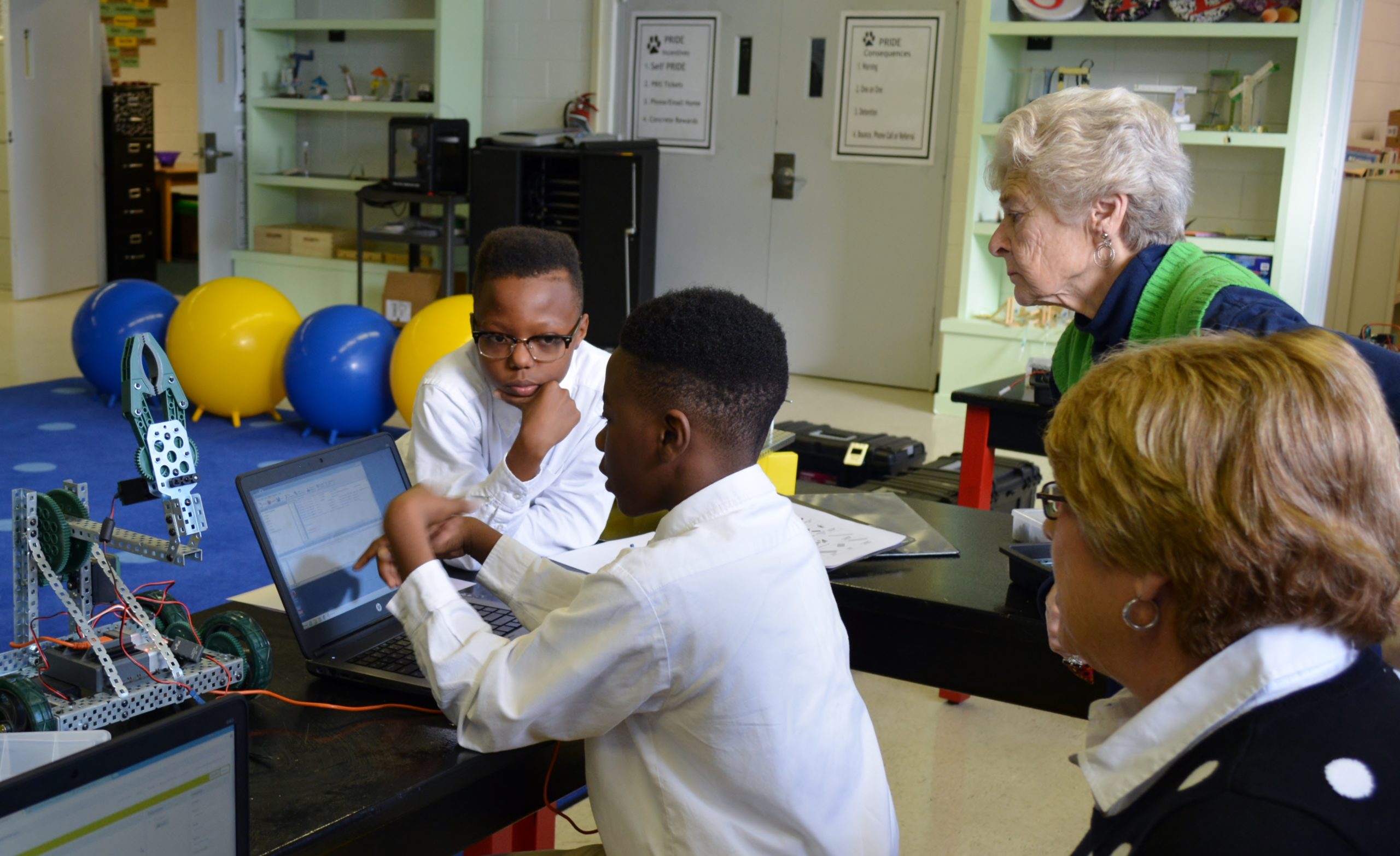 N.C. Holiday Flotilla board members watch as Virgo students demonstrate their STEM skills. For the second consecutive year, the flotilla has donated funds to the magnet middle school. Courtesy photo.