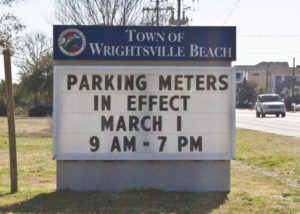 A sign reminded visitors and residents when parking season begins in Wrightsville Beach. Photo by Hannah Leyva.