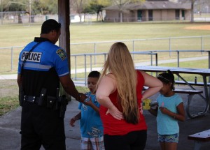 Officer Scott hands out police department stickers to children in the community. Photo by Christina Haley.