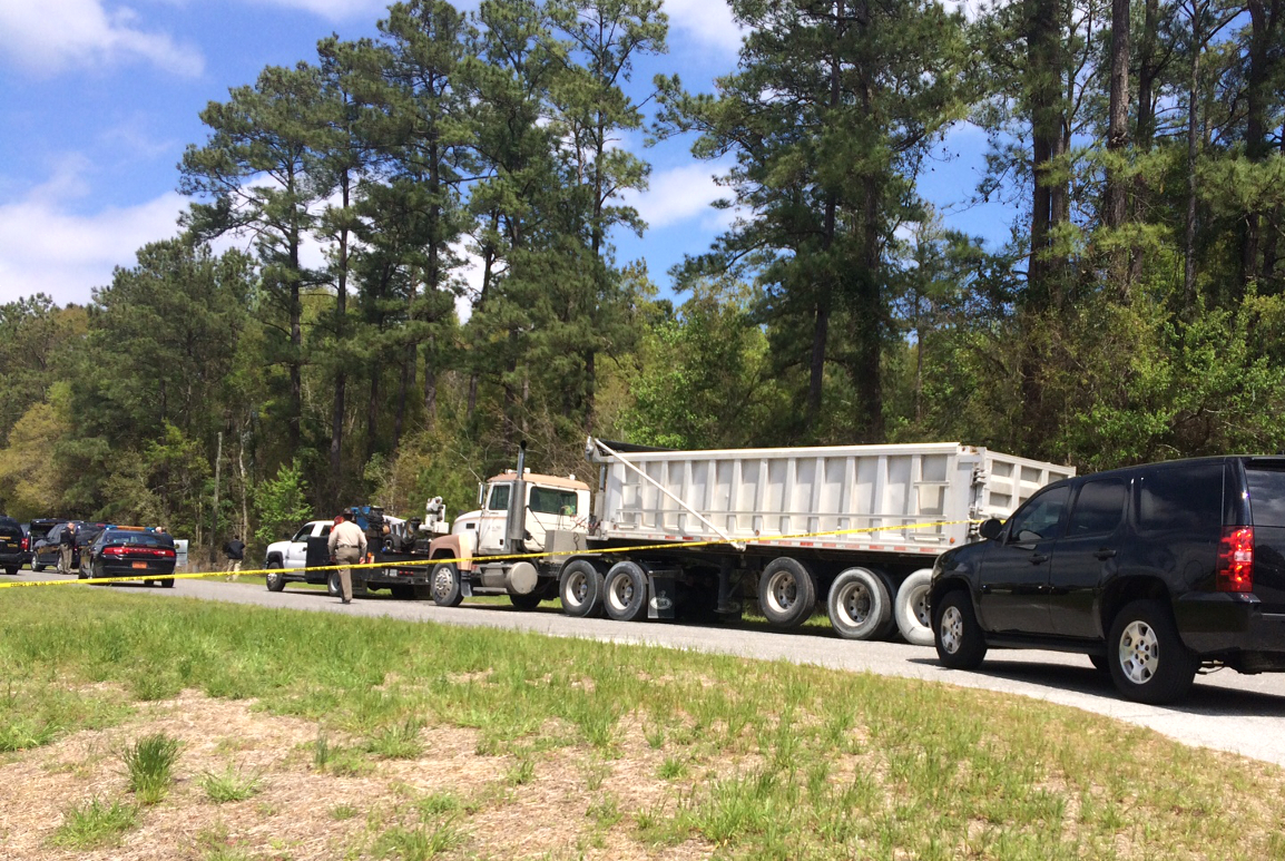 Detectives on the scene where a body was found by a trucker in a wooded area in Castle Hayne. Photo by Christina Haley.