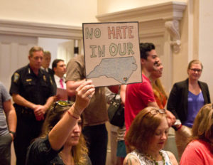 One of the many signs brought into Wilmington City Council Chambers on Tuesday night. Photo by Hannah Leyva.
