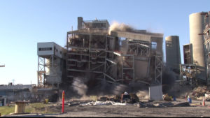 On Sunday, Duke Energy continued its mission to deconstruct the Sutton Plant, an old coal-fired plant known for its red and white striped smoke stacks.