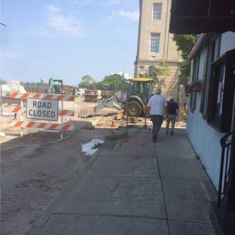 Strollers along Water traverse the construction zone to get to Market Street's sidewalk, which at a distance appears to be closed.