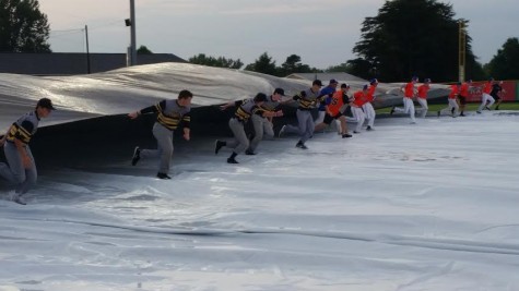 Both teams assisted in removing the tarp after a two-hour delay. 