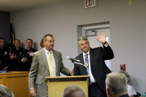 Former police Chief Dennis Cooper (left) places his badge on Chief Michael Bowden.