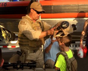 A U.S. Coast Guard member outfits a boy with military gear during National Night Out. Photos by Christina Haley.