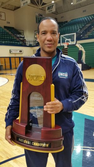 Coach Kevin Keatts is reunited with the national championship trophy after winning a national title at Louisville in 2013. Photo courtesy- UNCW Athletics.