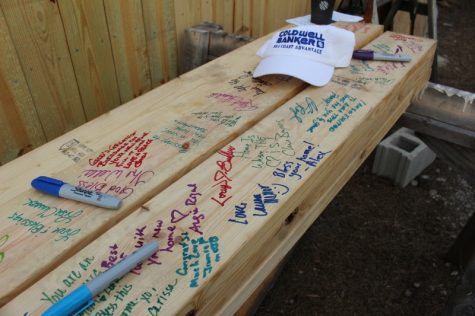 Volunteers, construction crew and city officials signed 2x6 boards to be used in Samantha Aryeetey's new Habitat for Humanity home. 