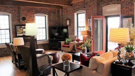 The downstairs living area is lined with exposed brick walks and windows that look out into the Cape Fear River. Photos by Christina Haley.