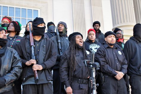 Alli Muhammad speaking at a news conference at the New Hanover County Courthouse. Many of the members carried weapons on their shoulders or holstered.