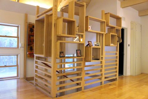 Wooden geometric shelving at the top of the staircase, follows the pattern of this unique modern-style home. (Photo by Christina Haley.)
