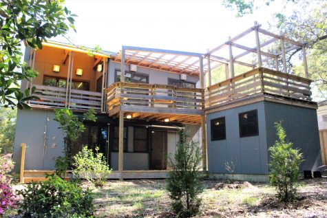 The back of the home is lined with patio space, and includes an outdoor shower and shed.