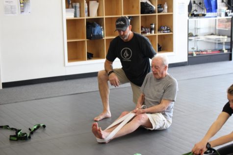 Mike Wilson helps newcomer Ronald Hovey work on stretching. (Photo Benjamin Schachtman)