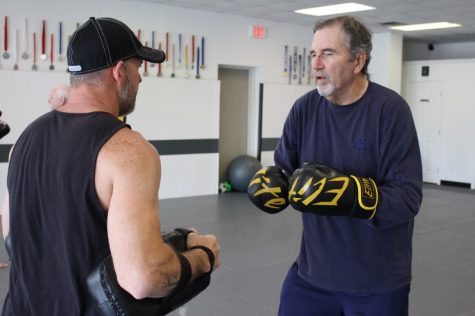 Parkinson's can't slow Tom Collins (right) down as he prepares to go southpaw on Rock Steady Boxing co-owner and trainer Mike Wilson (left). (Port City Daily photo/Benjamin Schachtman)