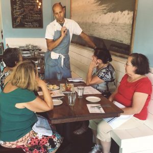 Chef Craig Love from the Surf House sharing some of the information behind the dishes they're sampling. (Port City Daily photo/COURTESY TASTING HISTORY TOURS)