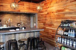 The shop has a comfortable rustic feel to it. There's a poured concrete bar, reclaimed wood walls, and the ceiling features wood from its original construction in 1948. (Port City Daily photo/CORY MANNION)