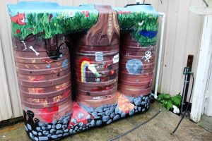 The 650 gallon cisterns at the back of the building. Over the past two days, a half inch of rainfall has already filled these tanks halfway up. (Port City Daily photo/CORY MANNION)
