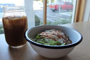 Cold brew coffee with a grit bowl, which comes with Heritage Farms pork shoulder, runny egg, heirloom tomatoes, onions, house made barbecue sauce, and of course, grits. (Port City Daily photo/CORY MANNION)