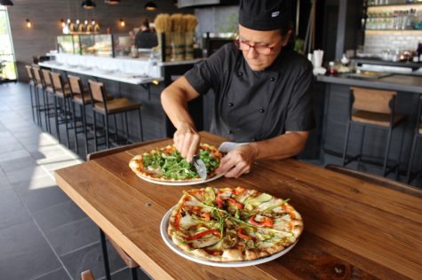 Chef Roberta Campani getting into a pizza with fresh shrimp, porcini mushrooms and arugula. (Port City Daily photo / BENJAMIN SCHACHTMAN)
