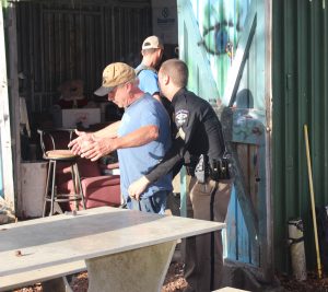 BCSO Deputy searching a man while executing arrest warrants Thursday (Port City Daily photo/MICHAEL PRAATS)