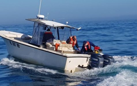 Coast Guard crew-members help keep a boat afloat off the coast of Carolina Beach. (Port City Daily photo | COURTESY US COAST GUARD)
