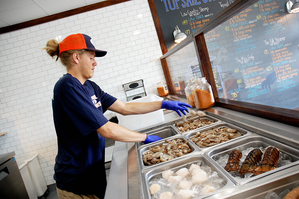 Mitchell Wells prepares shrimp to be added to Topsail Steamer's seafood pots in Wrightsville Beach. (Port City Daily/Johanna Ferebee)