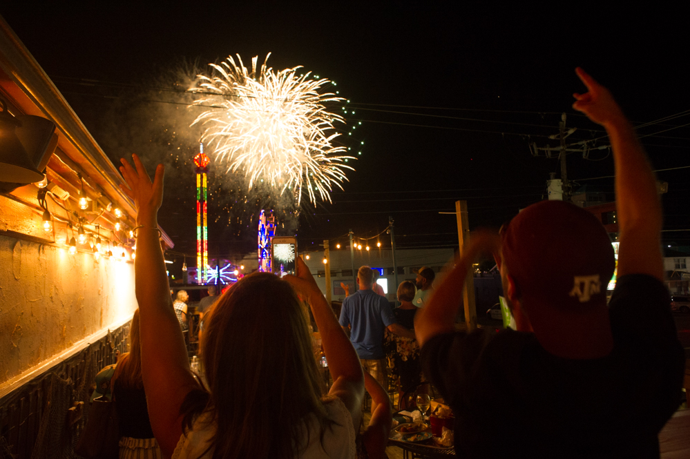 Samantha Morris and Will Darrough, both Wilmington residents, watch the Thursday night fireworks show from the patio of the Olde Salty, 9:07 p.m. (Port City Daily photo | Mark Darrough)