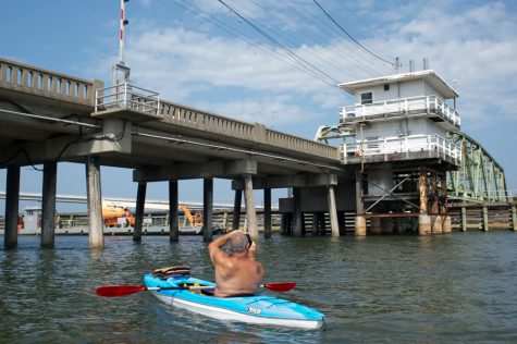A tourist visiting from Raleigh takes a picture of the old swing bridge in Surf City in August. (Port City Daily photo/Mark Darrough)
