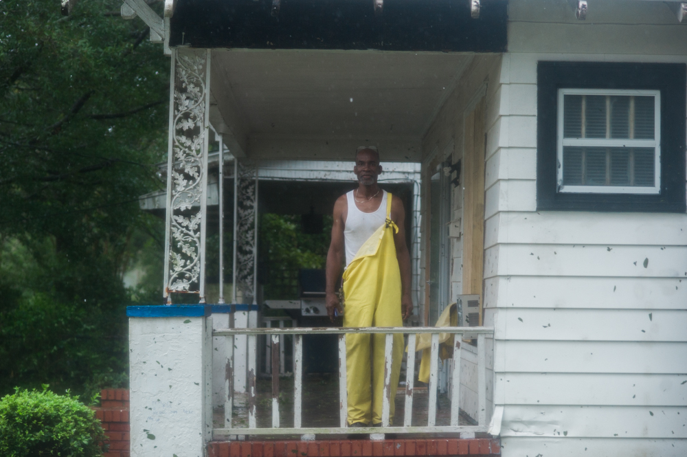 Marvin Haskins stands on his front porch in the Carolina Place neighborhood east of downtown Wilmington Friday morning during the calm between the inner bands of Hurricane Florence Friday morning. Haskins' fiancée has lived in the house, which appeared to be undamaged at that point, for 15 years. (Port City Daily photo | Mark Darrough)