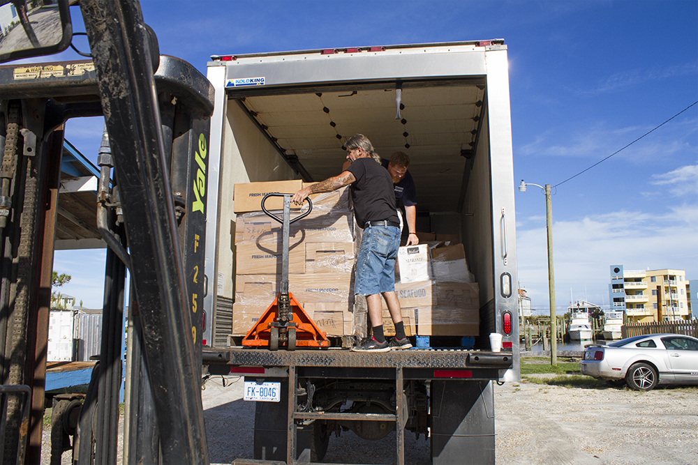 Employees of Blackburn Brothers in Carolina Beach unload the company's first shipment of product since Hurricane Florence hit.(Port City Daily photo/Johanna Ferebee)