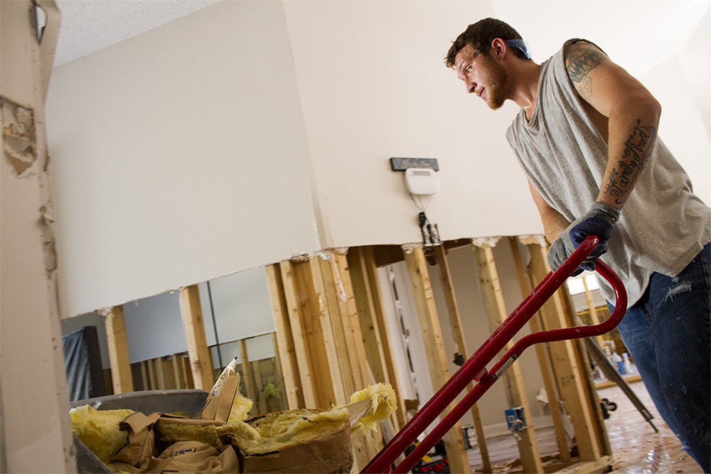 Brandon Phillips, an independent volunteer, moves molded sheetrock out of a flood damaged home in Leland. (Port City Daily photo/Johanna Ferebee)