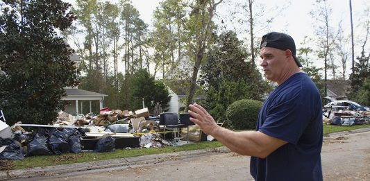 Mark Cerqueira surveys his damaged belonging on the front lawn of his home in Leland, where floodwaters filled over three feet of his home. (Port City Daily photo/Johanna Ferebee)