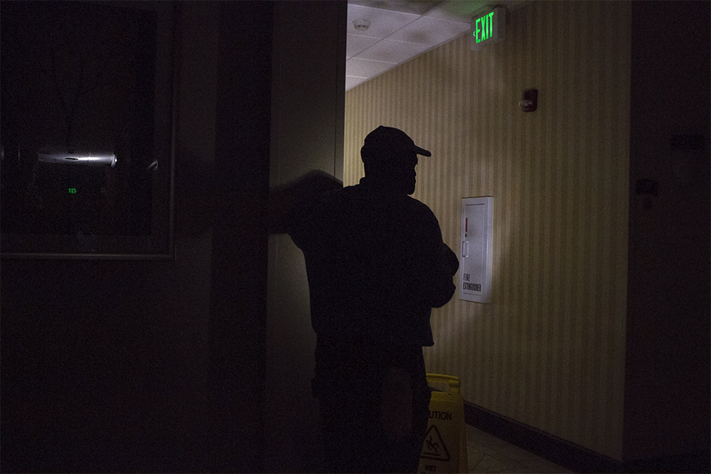 A hotel employee in Wilmington shines a light in a dark hallway during Hurricane Florence while power outages across the region lasted for several days. (Port City Daily photo/Johanna Ferebee)
