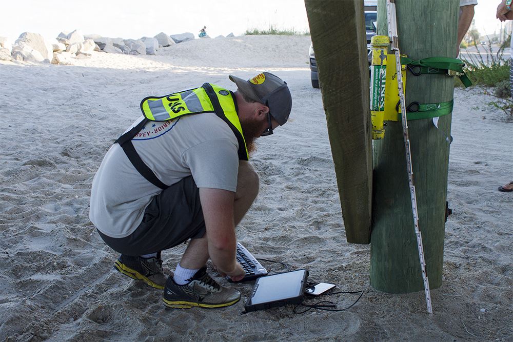 James Stonecypher, a hydrologic technician for United States Geological Survey, installs a pressure sensor to Carolina Beach Pier Wednesday, Sept. 14. Solely relying on temporary gauges like these, rather than permanent National Weather Service markers, make detailed prediction modeling more difficult to interpret and translate risk. (Port City Daily photo/Johanna Ferebee)