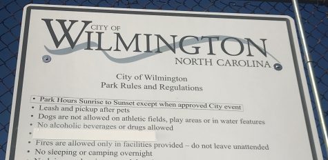 A sign at Empie Park appears to have been recently modified to remove language prohibiting firearms. (Port City Daily photo / Benjamin Schachtman)