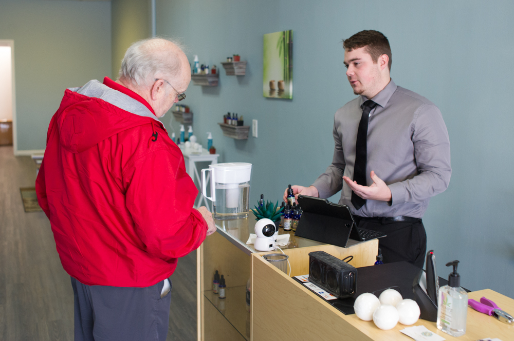 Surf City resident Rick Leahigh, left, discusses products for his knee and hip pain with Your CBD Store employee Jacob Morse. (Port City Daily photo/Mark Darrough)